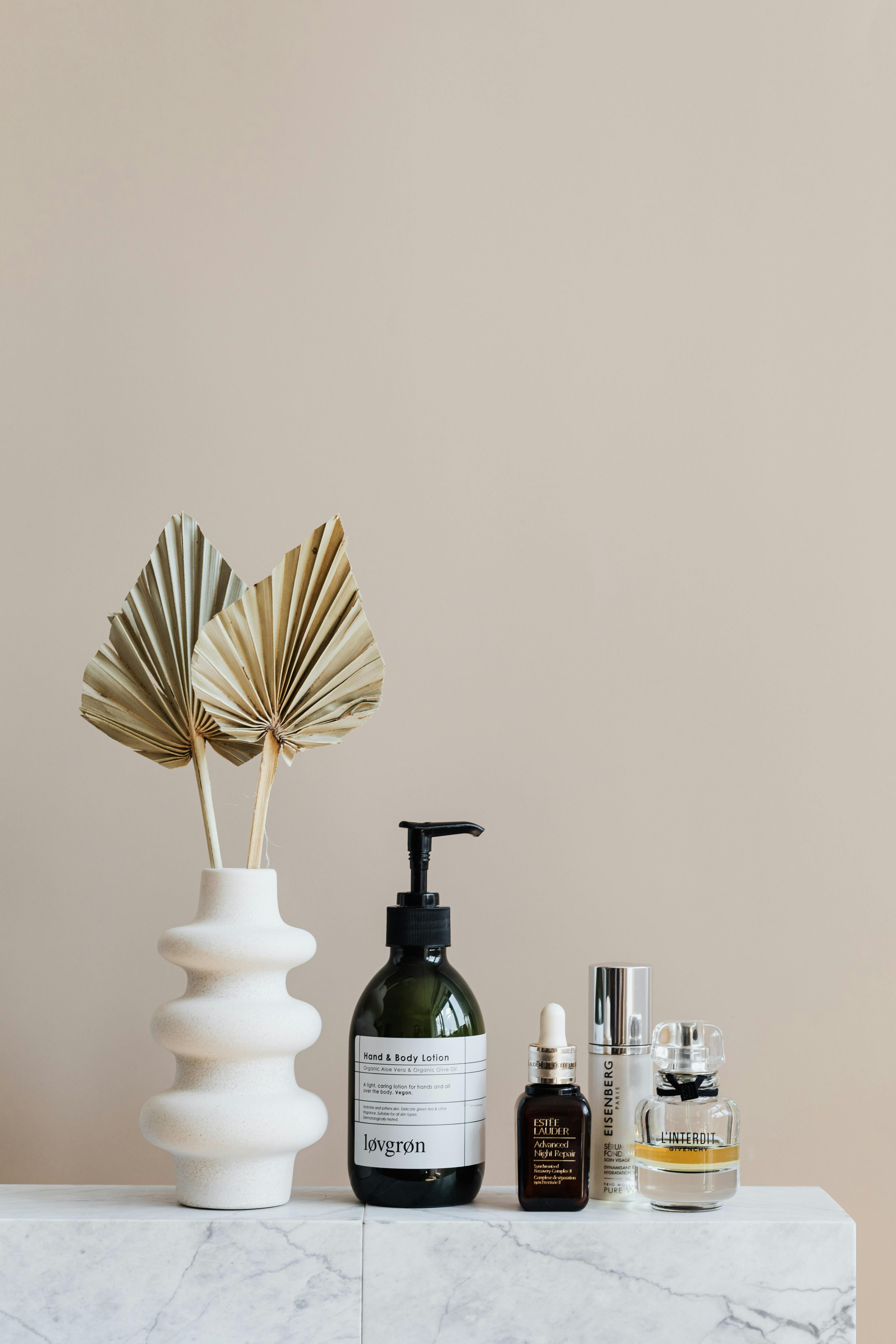 pexels-photo-4202325-4202325 Minimalist bathroom shelf featuring skincare bottles and decorative beige vase.