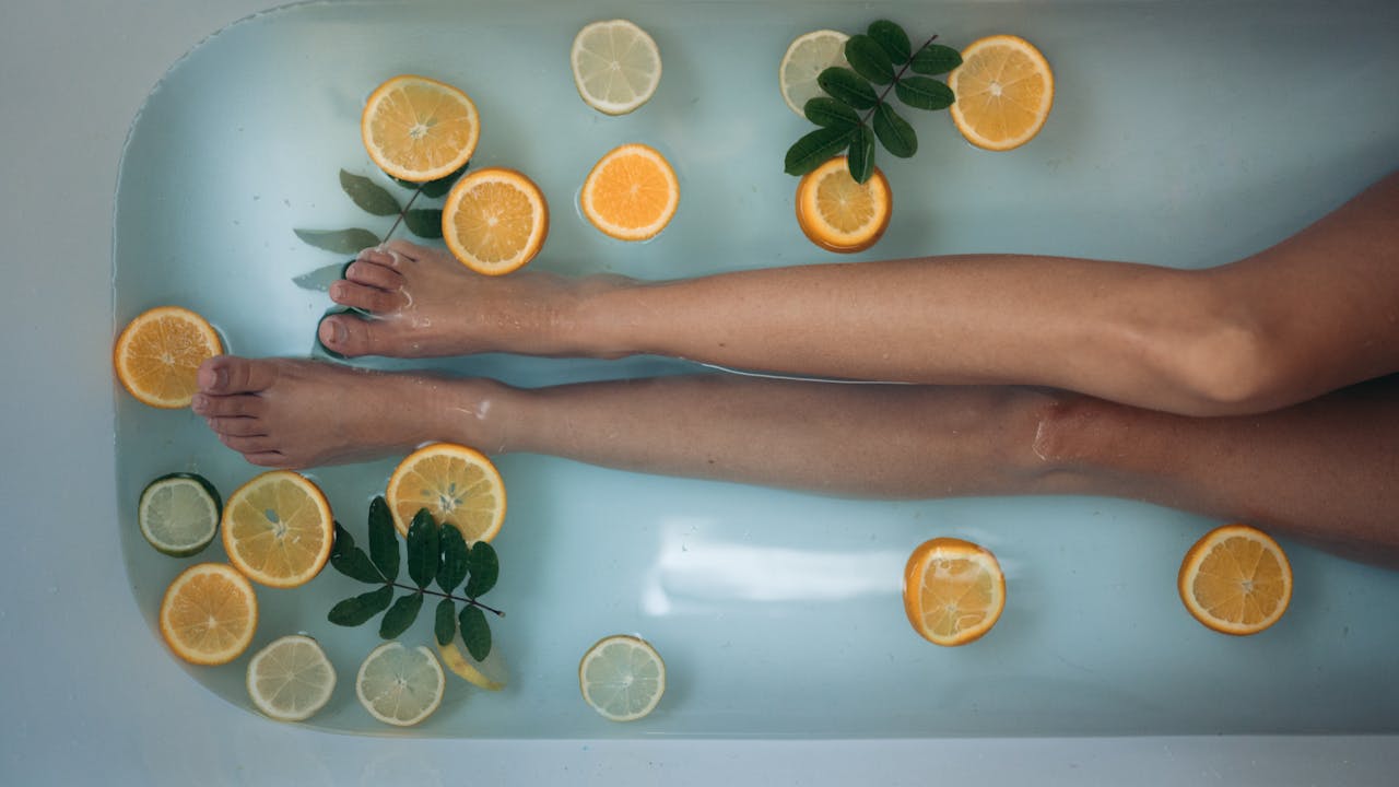 pexels-photo-4426553 A soothing spa experience with citrus slices and legs submerged in a bathtub, epitomizing relaxation and self-care.