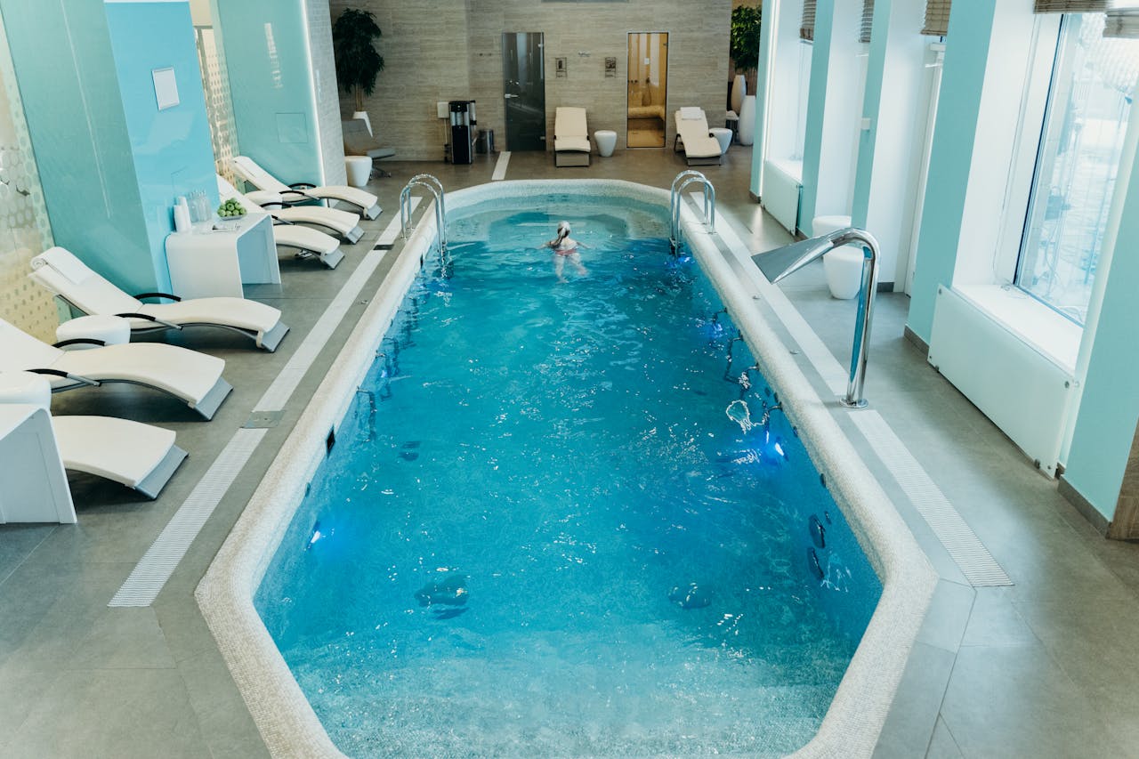 pexels-photo-7222170 Bright indoor spa pool with lounge chairs and calm atmosphere, ideal for relaxation.