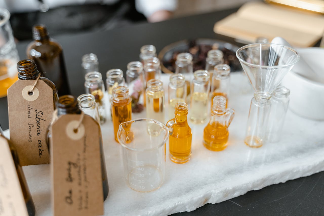 pexels-photo-8450469 Aromatic essential oils in glass vials on a white surface, arranged for aromatherapy use.